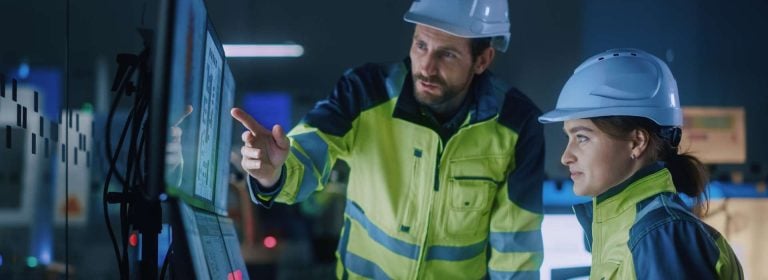 Two industrial workers planning smart safety on a computer screen.